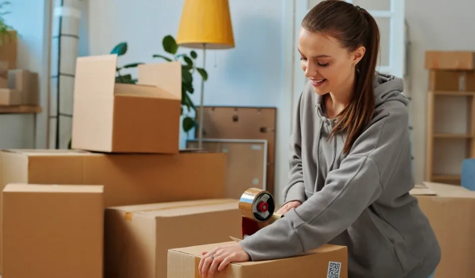 Young woman packing moving boxes